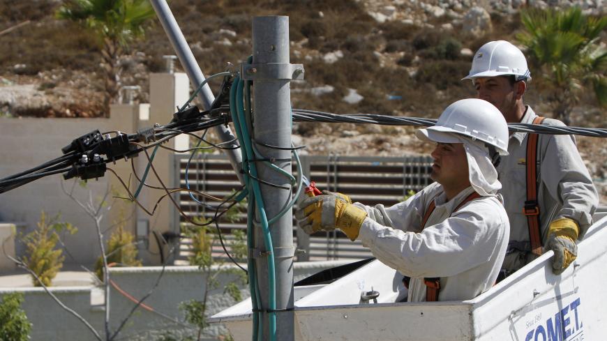 Electricians install new power transmission lines at a construction site in the West Bank city of Ramallah September 3, 2012. The cash-strapped government of the occupied West Bank, the Palestinian Authority, is so behind with its bills that an Israeli electricity supplier has threatened to cut the power unless they pay outstanding debt of almost $80 million. Picture taken September 3, 2012. To match Feature PALESTINIANS/ECONOMY  REUTERS/Mohamad Torokman (WEST BANK - Tags: POLITICS BUSINESS) - GM1E8951PIW01