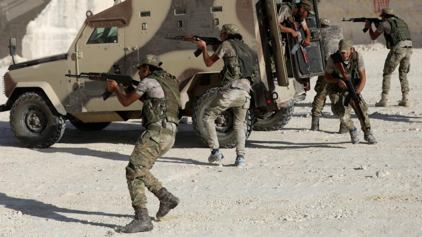 Fighters from Free Syrian Army (National Brigade) demonstrate their skills during a military display as part of a graduation ceremony in the Syrian city of al-Bab, Syria September 27, 2017. REUTERS/Khalil Ashawi - RC13EEB7DF60