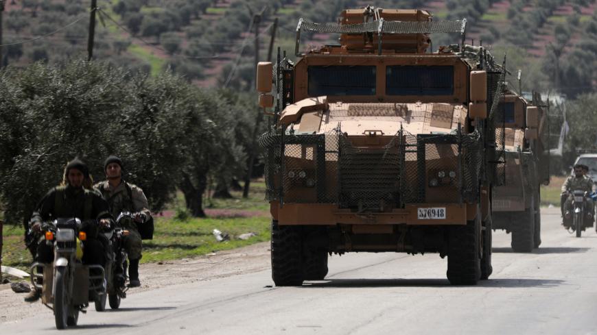 Turkish-backed Free Syrian army members ride on a motorbike near a Turkish military vehicle in Afrin, Syria March 19, 2018. REUTERS/Khalil Ashawi - RC1F92C97600
