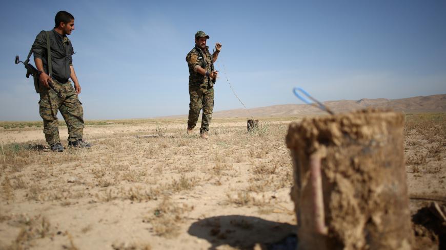 Members of the Sinjar Resistance Units (YBS), a militia affiliated with the Kurdistan Workers' Party (PKK), disarm an improvised explosive device placed by Islamic State fighters near the village of Umm al-Dhiban, northern Iraq, April 30, 2016. They share little more than an enemy and struggle to communicate on the battlefield, but together two relatively obscure groups have opened up a new front against Islamic State militants in a remote corner of Iraq. The unlikely alliance between the Sinjar Resistance 