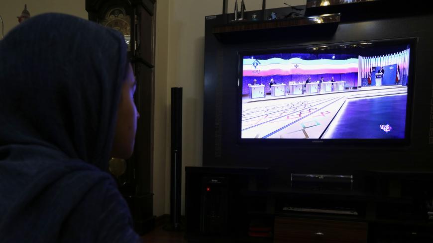 An Iranian woman watches the six presidential candidates 
for Iran's elections attending a live debate on state TV in Tehran on April 28, 2017. 
Iran will air live debates on state television ahead of May's presidential election, the interior ministry, reversing a decision to show recorded versions that had triggered an outcry. / AFP PHOTO / ATTA KENARE        (Photo credit should read ATTA KENARE/AFP/Getty Images)