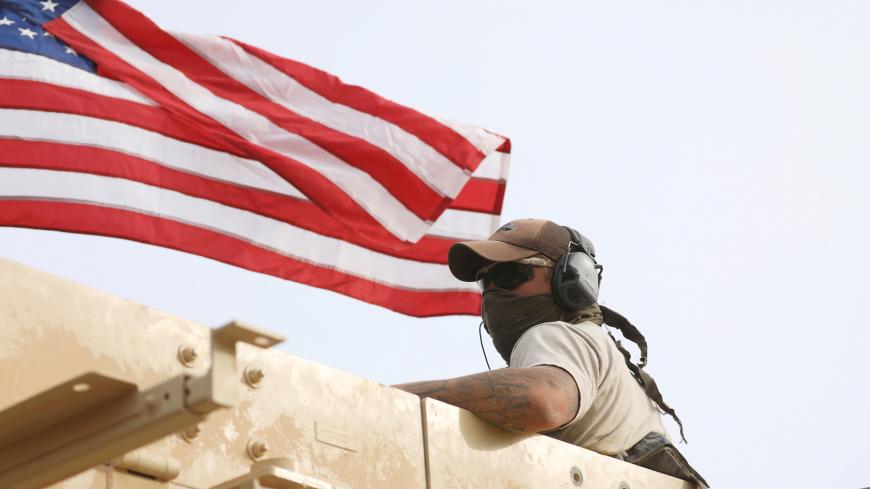 A member of U.S forces rides on a military vehicle in the town of Darbasiya next to the Turkish border, Syria April 28, 2017. REUTERS/Rodi Said - RC1FBF066A10
