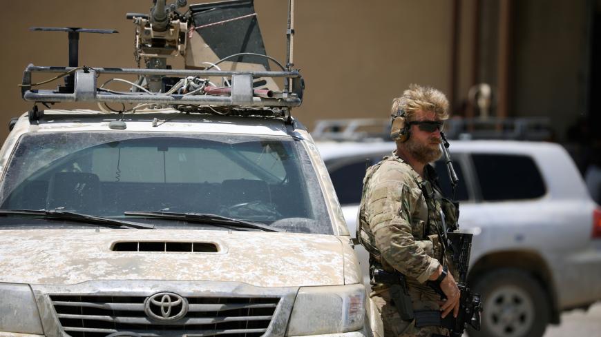 U.S army soldier holds a gun as he stands guard next to an armoured vehicle as Brett McGurk, U.S. envoy to the coalition against Islamic State, visits the town of Tabqa, Syria June 29, 2017. REUTERS/Rodi Said - RC1AEEE29680