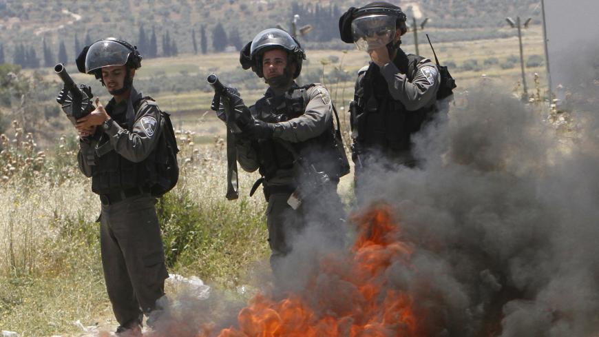 Israeli border policemen take up position during clashes with Palestinian protesters following a protest marking Nakba Day near Israel's Hawra checkpoint near the West Bank city of Nablus May 16, 2015. Palestinians marked "Nakba" (Catastrophe) on May 15 to commemorate the expulsion or fleeing of some 700,000 Palestinians from their homes in the war that led to the founding of Israel in 1948. REUTERS/Abed Omar Qusini - GF10000096946