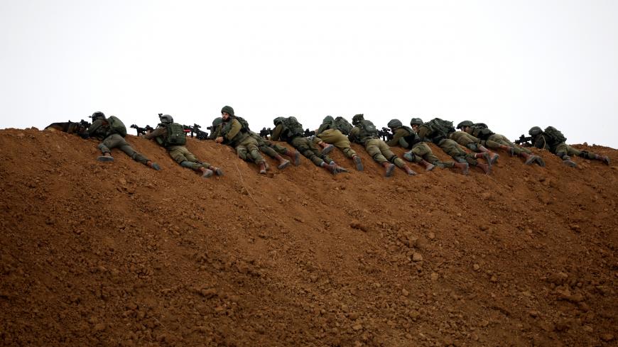 Israeli soldiers are seen next to the border fence on the Israeli side of the border with the northern Gaza Strip, Israel, March 30, 2018. REUTERS/Amir Cohen - RC11D877BB40