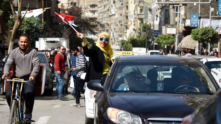 An Egyptian woman waves her national flag out of the window of a taxi on the first day of voting for the 2018 presidential elections on March 26, 2018.
Egyptians head to the polls in a three-day vote to choose between incumbent Abdel Fattah al-Sisi and little-known candidate Moussa Mostafa Moussa, who has struggled to make the case he is not Sisi's minion. / AFP PHOTO / KHALED DESOUKI        (Photo credit should read KHALED DESOUKI/AFP/Getty Images)