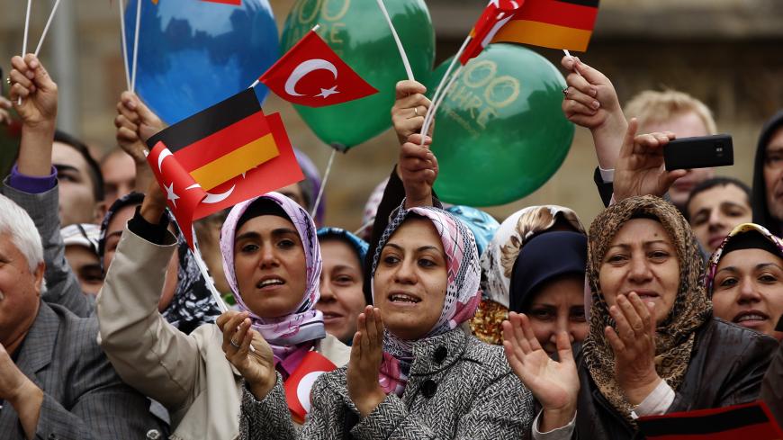 Turkish women wave German and Turkish flags during a visit of Turkey's President Abdullah Gul in Osnabrueck September 20, 2011. REUTERS/Ina Fassbender (GERMANY - Tags: POLITICS) - BM2E79K144D01