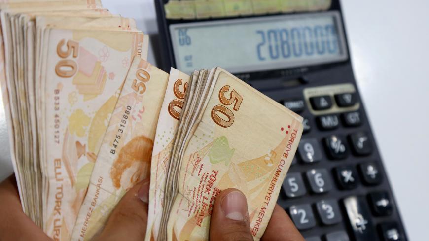 A money changer counts Turkish lira banknotes at a currency exchange office in Diyarbakir, Turkey May 23, 2018. REUTERS/Sertac Kayar - RC1EF7A7FF30