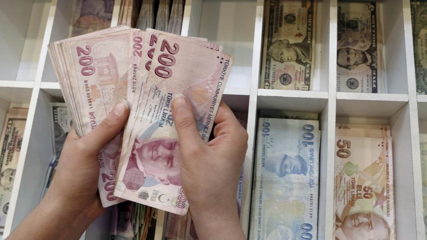 A money changer counts Turkish lira bills at an currency exchange office in central Istanbul, Turkey, August 21, 2015. REUTERS/Murad Sezer/File Photo - S1BETTHGKMAB