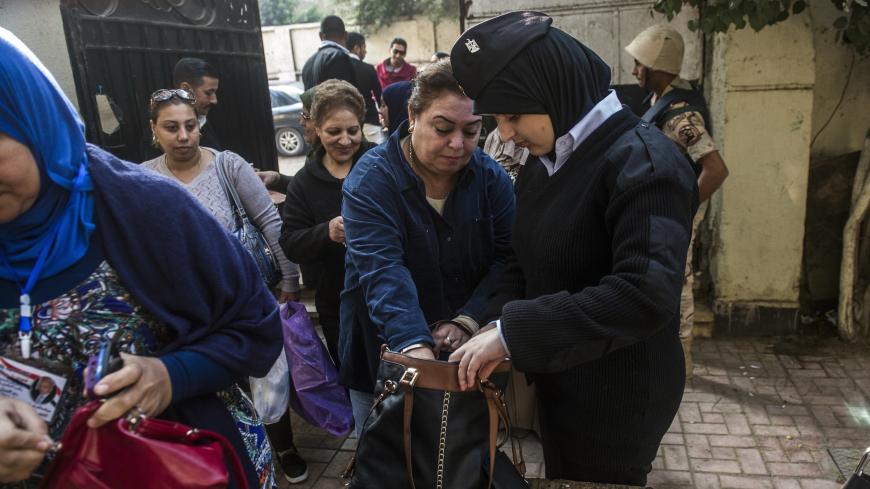 An Egyptian policewoman checks women's handbags outside a polling station in the capital Cairo on November 22, 2015, on the first day of the second and final round of the country's parliamentary elections. Egyptians began voting Sunday across 13 of the country's 27 provinces in the second phase of parliamentary elections after a low turnout marred the first stage in the absence of any strong opposition. AFP PHOTO / KHALED DESOUKI (Photo credit should read KHALED DESOUKI/AFP/Getty Images)