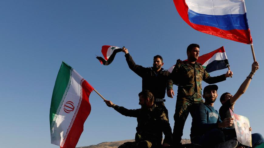 Syrians wave Iranian, Russian and Syrian flags during a protest against U.S.-led air strikes in Damascus,Syria April 14,2018.REUTERS/ Omar Sanadiki     TPX IMAGES OF THE DAY - RC1815671B90