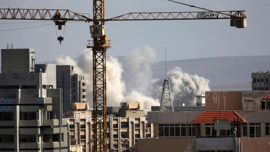 A construction crane is seen as smoke rises from Yarmouk Palestinian camp in Damascus, Syria April 21, 2018. REUTERS/Ali Hashisho - RC16C2D4AC60
