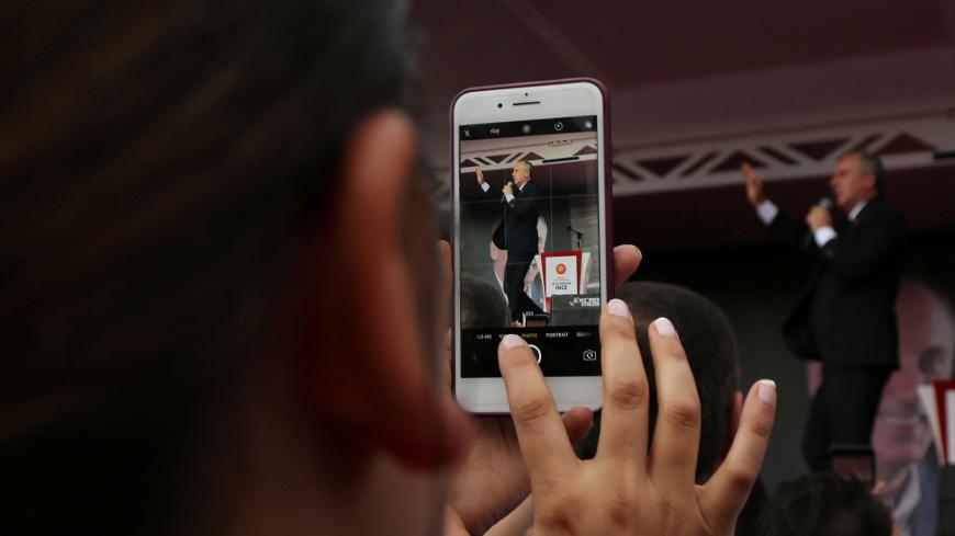 A woman takes a picture of Muharrem Ince, presidential candidate of the main opposition Republican People's Party (CHP), by her mobile phone during an election rally in Diyarbakir, Turkey June 11, 2018. REUTERS/Sertac Kayar - RC1200C00C70