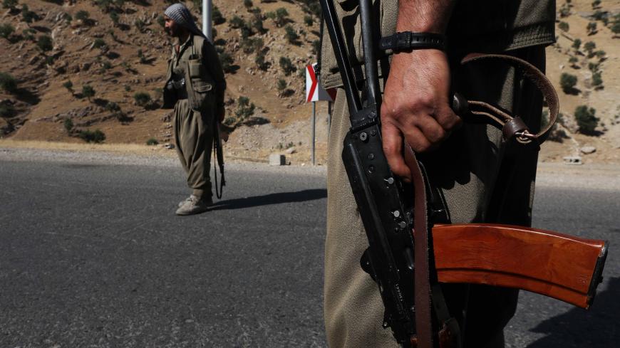 A member of the Kurdistan Workers' Party (PKK) carries an automatic rifle on a road in the Qandil Mountains, the PKK headquarters in northern Iraq, on June 22, 2018. - Hundreds of Iraqi Kurds marched Friday to protest Turkish strikes against the Kurdistan Workers' Party (PKK) after Turkey's President Recep Tayyip Erdogan said Ankara would press an operation against its bases. (Photo by SAFIN HAMED / AFP) (Photo credit should read SAFIN HAMED/AFP/Getty Images)