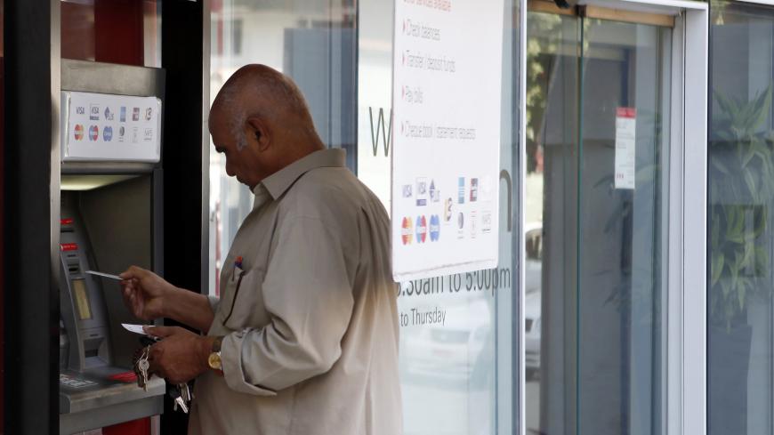 A man withdraws money from an ATM machine outside of a bank in Cairo, August 27, 2012. Demand for the Egyptian central bank's repurchasing agreement (repo) facility has fallen back after shooting up in June, indicating that short-term pressure on the banking system may be easing as more money flows into the country. The government introduced the facility in March last year to boost liquidity in Egypt's turbulent financial markets a month after President Hosni Mubarak resigned in the wake of a popular uprisi