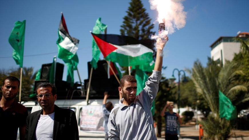 A man releases fireworks during celebrations after rival Palestinian factions Hamas and Fatah signed a reconciliation deal, in Gaza City October 12, 2017. Picture taken October 12, 2017. REUTERS/Suhaib Salem - RC1D1B95D160