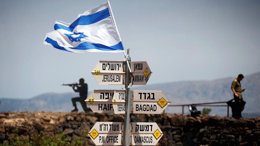 An Israeli soldier stands next to signs pointing out distances to different cities, on Mount Bental, an observation post in the Israeli-occupied Golan Heights that overlooks the Syrian side of the Quneitra crossing, Israel May 10, 2018. REUTERS/Ronen Zvulun TPX IMAGES OF THE DAY - RC1D6EF6AF90
