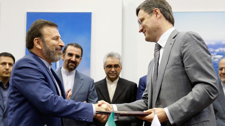 Russian Energy Minister Alexander Novak and Iranian Communications Minister Mahmoud Vaezi exchange documents during a signing ceremony after their meeting in Moscow, Russia, July 29, 2016.  REUTERS/Maxim Zmeyev - D1BETSIUABAB