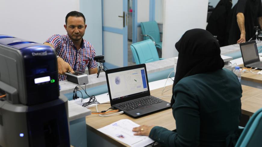 A man scans his thumbprint during a registration process for a new Identification card at al-Bab city council offices in the northeast of Aleppo, Syria July 15, 2018. Picture Taken July 15, 2018. REUTERS/ Khalil Ashawi - RC1F92F66FE0