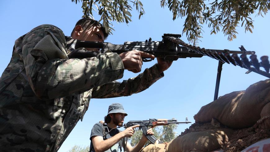 Rebel fighters from the Suqur Al-Sham brigades take a position in the countryside of the northern Idlib province on August 17, 2018. (Photo by OMAR HAJ KADOUR / AFP)        (Photo credit should read OMAR HAJ KADOUR/AFP/Getty Images)
