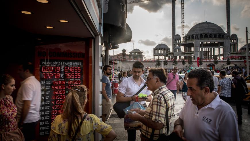 ISTANBUL, TURKEY - AUGUST 29: People wait to change money at a currency exchange office in front of the underconstruction, Taksim Square Mosque on August 29, 2018 in Istanbul, Turkey. Turkey's lira extended its slump to a third day to 6.45 against the dollar after the central bank announced it would alter Turkish banks borrowing limits on overnight transactions, the move failed to reassure investors and combined with the decision by ratings agency Moody's to downgrade the credit rating of twenty Turkish fi