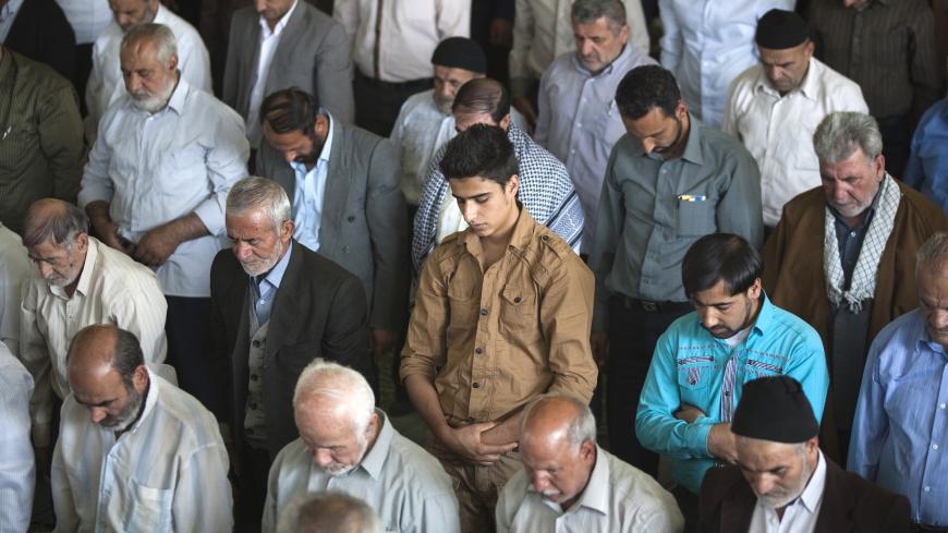 EDITORS' NOTE: Reuters and other foreign media are subject to Iranian restrictions on leaving the office to report, film or take pictures in Tehran.

Iranian Sunni worshippers (centre) pray as they stand with Shi'ite Muslims during Tehran's Friday prayers October 14, 2011. REUTERS/Morteza Nikoubazl (IRAN - Tags: POLITICS RELIGION) - GM1E7AE1UKE01