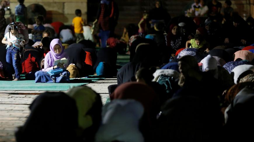 An Egyptian Muslim girl reads the koran during an evening prayers called "Tarawih" on Laylat al-Qadr or Night of Decree, at Amr Ibn El-Aas mosque, the first and oldest mosque ever built on the land of Egypt, during the Muslim holy month of Ramadan in old Cairo, Egypt June 21, 2017. REUTERS/Amr Abdallah Dalsh - RC1ECD154720