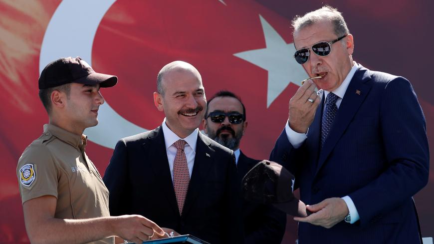 Turkish President Tayyip Erdogan, accompanied by Interior Minister Suleyman Soylu, blows a watchmen whistle during a ceremony in Istanbul, Turkey, August 25, 2017. REUTERS/Murad Sezer - RC16D1688D50