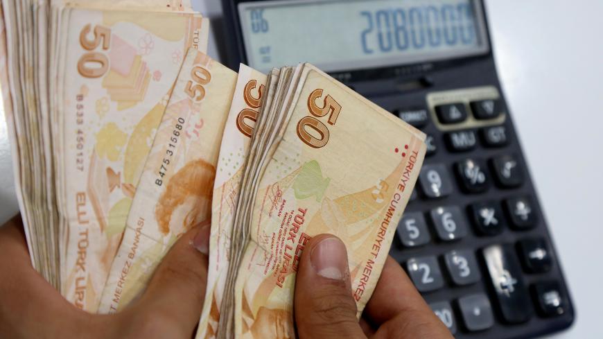 A money changer counts Turkish lira banknotes at a currency exchange office in Diyarbakir, Turkey May 23, 2018. REUTERS/Sertac Kayar - RC1EF7A7FF30