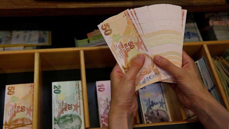 A money changer counts Turkish lira banknotes at a currency exchange office in Istanbul, Turkey August 13, 2018. REUTERS/Murad Sezer - RC139D2160B0