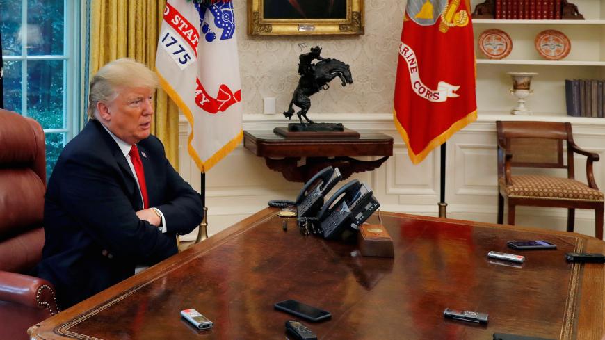 U.S. President Donald Trump answers a reporter's question as eight different phones and recording devices placed on his desk by reporters and White House staff members record his words during an interview with Reuters in the Oval Office of the White House in Washington, U.S. August 20, 2018. REUTERS/Leah Millis TPX IMAGES OF THE DAY - RC1CEA11EEE0