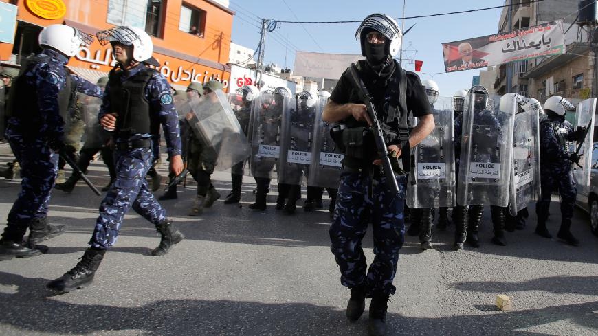 Members of Palestinian security forces stand guard during a protest organised by Hizb-ut Tahrir in Hebron, in the occupied West Bank, April 14, 2018. REUTERS/Mussa Qawasma - RC1C754DC650