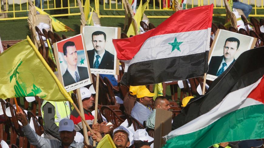 Supporters of Lebanon's Hezbollah leader Sayyed Hassan Nasrallah carry flags and pictures of Syria's President Bashar al-Assad during a rally marking al-Quds Day, (Jerusalem Day) in Maroun Al-Ras village, near the border with Israel, southern Lebanon June 8, 2018. REUTERS/Aziz Taher - RC150991C950