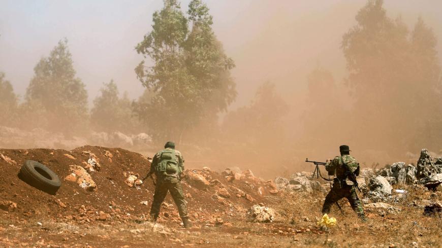 Syrian fighters fire their rifles as they attend a mock battle in anticipation of an attack by the regime on Idlib province and the surrounding countryside, during a graduation of new Hayat Tahrir al-Sham (HTS) members at a camp in the countryside of the northern Idlib province on August 14, 2018. (Photo by OMAR HAJ KADOUR / AFP)        (Photo credit should read OMAR HAJ KADOUR/AFP/Getty Images)