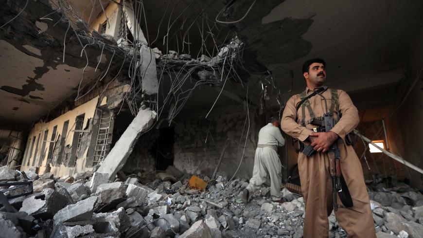 Iranian Kurdish Peshmerga members of the Iranian Kurdistan Democratic Party (KDPI) check the damage after a rocket attack inside their headquarters in Koysinjaq, 100 kilometres east of Arbil, the capital of the autonomous Kurdish region of eastern Iraq, on September 8, 2018. - At least a dozen members of the Iranian Kurdish rebel group were killed on September 8 in the a rocket attack on their headquarters carried out by Iran's Revolutionary Guards. The Kurdistan Democratic Party of Iran (KDPI) has carried 