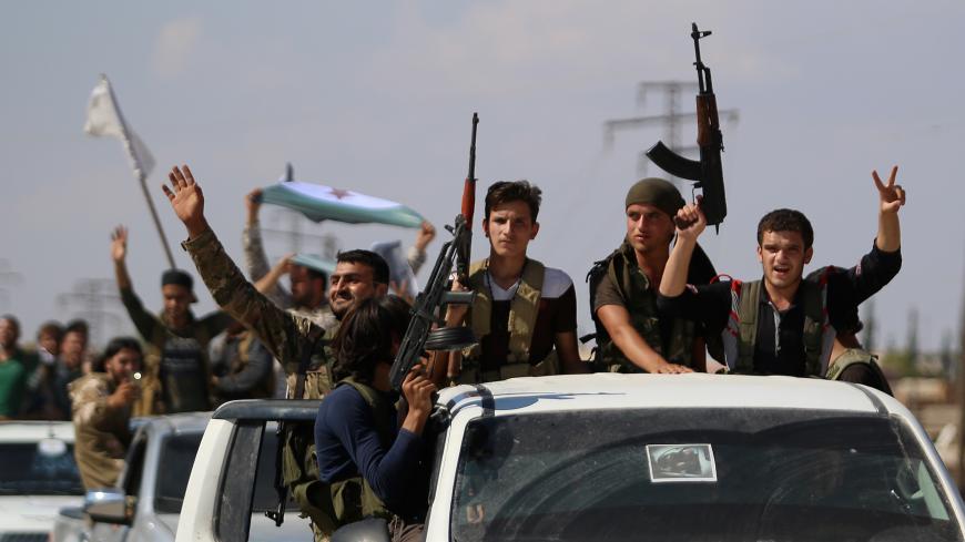 Syrian rebel fighters from the recently-formed "National Liberation Front" parade following military training at an unknown location in the northern countryside of the Idlib province on September 11, 2018, in anticipation for an upcoming government forces offensive. - The Syrian regime and its Russian ally are threatening an offensive to retake the northwestern province of Idlib, Syria's last rebel bastion. (Photo by Aaref WATAD / AFP) (Photo credit should read AAREF WATAD/AFP/Getty Images)