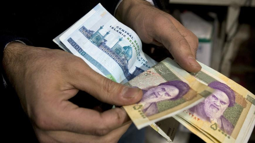 A vendor counts money in a shop in Tehran's Grand Bazaar January 19, 2009. Tumbling oil prices could make it harder for Iran to shrug off U.S. and U.N. sanctions and add to pressure on the world's fourth-largest crude producer to halt nuclear work the West suspects is aimed at making bombs. Iran says it can cope even if oil falls much more and shows no sign that economic problems may prompt it to soften its nuclear defiance, even if it is promised an end to isolation as well as enhanced trade and other swee