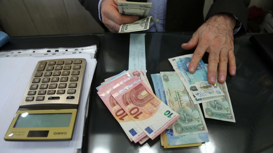 A money changer holds U.S. dollar banknotes as he counts other currency banknotes at Grand Bazaar in Tehran, Iran October 14, 2017. Nazanin Tabatabaee Yazdi/TIMA via REUTERS ATTENTION EDITORS - THIS IMAGE WAS PROVIDED BY A THIRD PARTY. - RC1B64997900