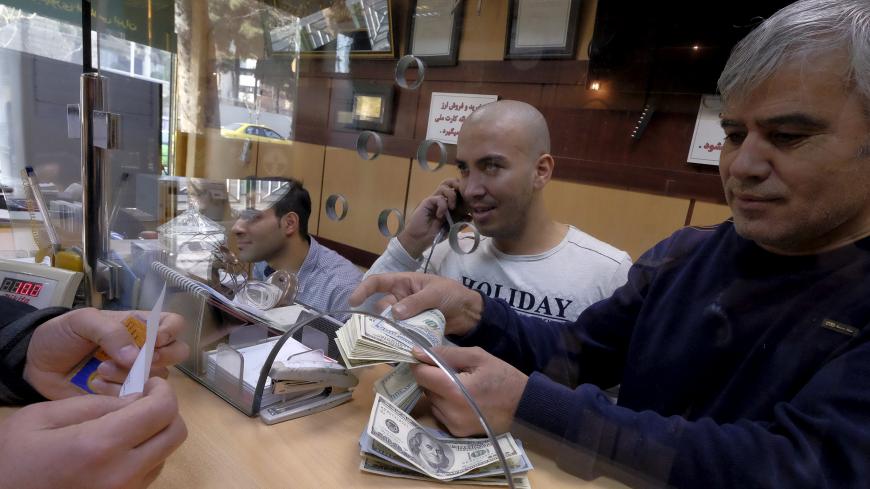 A currency exchange dealer counts U.S. dollar banknotes at his shop in a shopping centre in northern Tehran, January 17, 2016. REUTERS/Raheb Homavandi/TIMAATTENTION EDITORS - THIS IMAGE WAS PROVIDED BY A THIRD PARTY. FOR EDITORIAL USE ONLY.  - GF20000097640