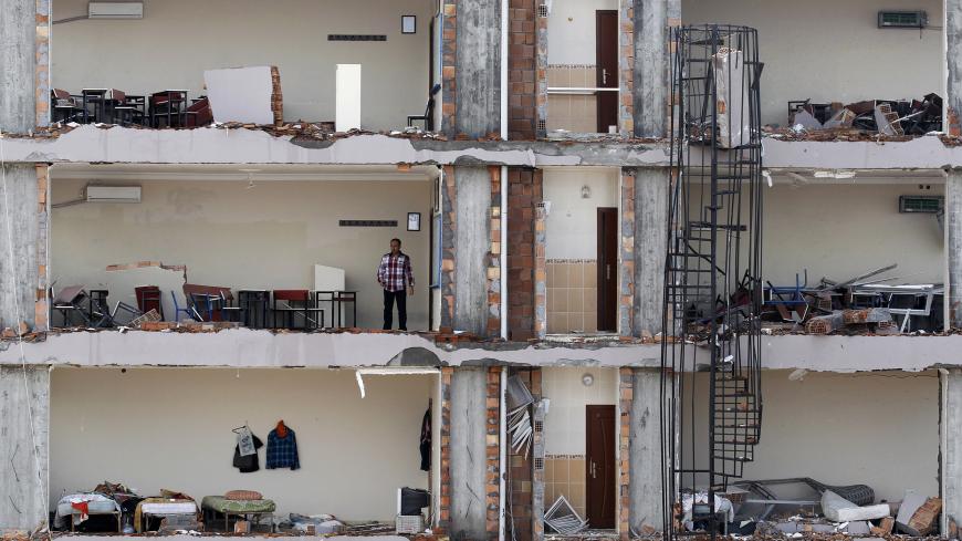 A man checks an apartment on a damaged building at the site of a blast in the town of Reyhanli in Hatay province, near the Turkish-Syrian border, May 13, 2013. Syria's information minister has blamed Turkey's government for deadly car bombings near the Syrian border and branded Prime Minister Tayyip Erdogan a "murderer", state-run Russian TV company RT reported on Monday. It said he repeated a denial of Syrian involvement in car bombings that killed 46 people on Saturday in the Turkish border town of Reyhan