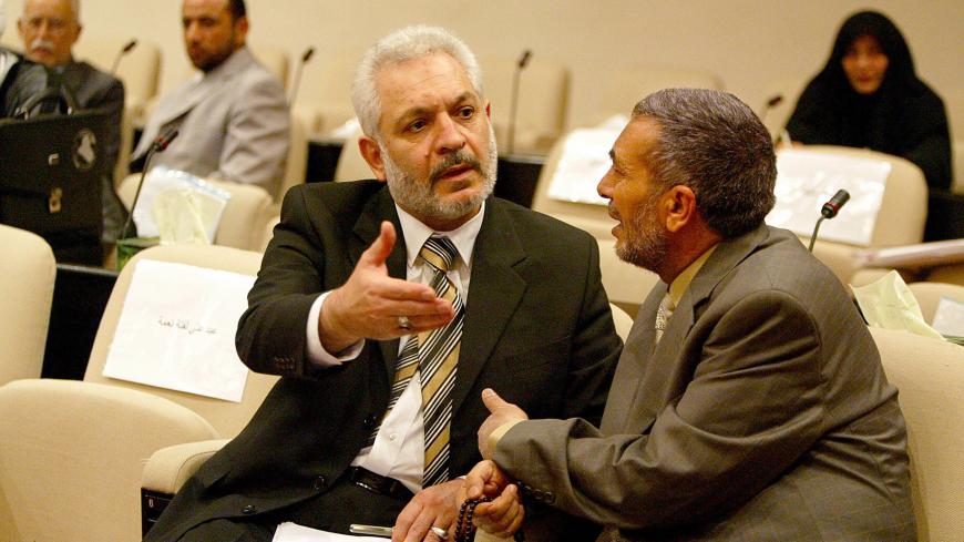 Baghdad, IRAQ:  Iraqi deputy Ali al-Adib (L), member of the Shiite Iraqi al-Dawa Party chats with  Sunni speaker Mahmud Mashhadani prior the start of the parliament session in Baghdad's heavily fortified green zone, 17 May 2006. Iraqi prime minister designate Nuri al-Maliki will present his cabinet line-up for parliamentary approval on Saturday, deputy parliamentary speaker Sheikh Khalid al-Attiya said today.       AFP PHOTO/POOL SABAH ARAR  (Photo credit should read SABAH ARAR/AFP/Getty Images)