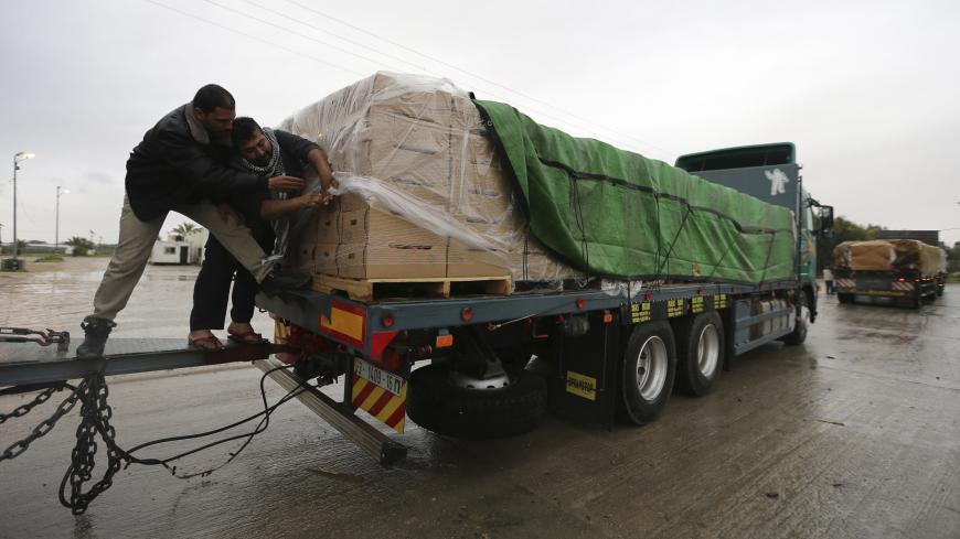 Palestinians cover cartons containing vegetables before exporting them to Israel, at the Kerem Shalom crossing in Rafah in the southern Gaza Strip  March 12, 2015. Israel imported its first fruit and vegetables from the Gaza Strip in almost eight years on Thursday, in a partial easing of an economic blockade maintained since the Islamist group Hamas seized control of the Palestinian territory. Twenty-seven tonnes of tomatoes and five tonnes of eggplants were trucked across the border under an Israeli plan t