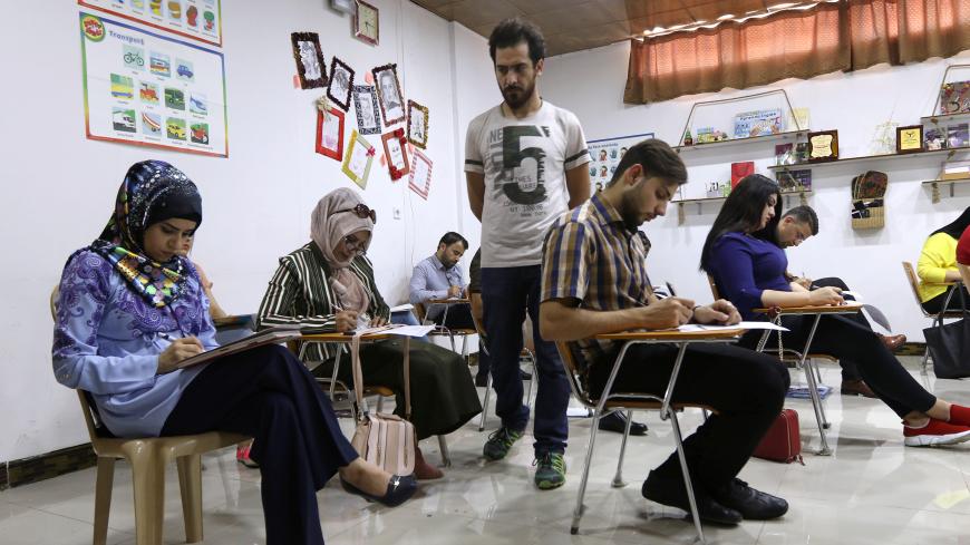 Iraqi students take an English language exam at a bookstore in Kirkuk, Iraq, July 24, 2018, Picture taken July 24, 2018. REUTERS/Ako Rasheed - RC1F5E5EA660
