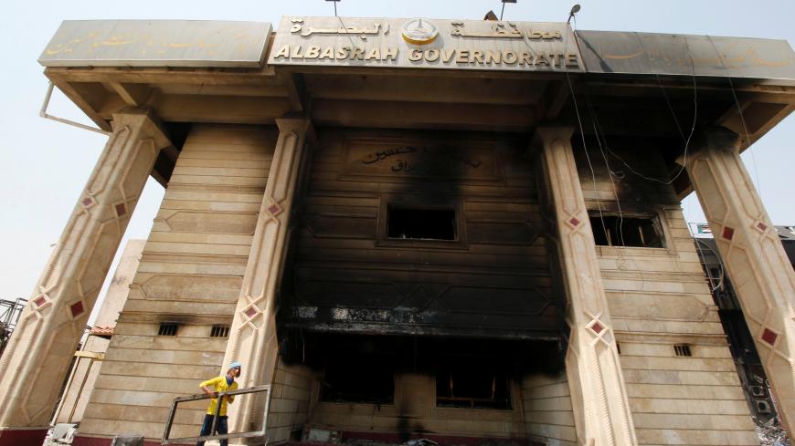 A man cleans the building of Basra Governorate after demonstrations during which protesters torched the Basra Governorate in Basra, Iraq September 9, 2018. REUTERS/Essam al-Sudani - RC1499F86B00