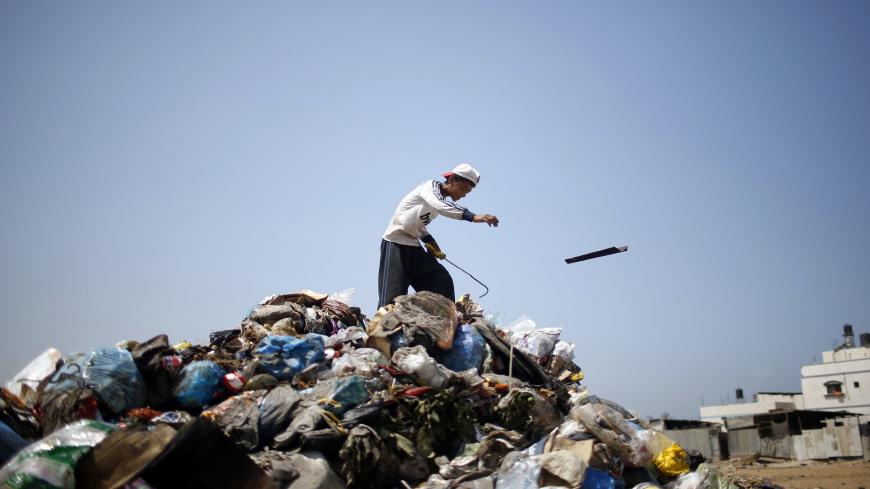 A Palestinian sifts through garbage for salvageable items at a local dump site, in the east of Gaza City September 2, 2013.  REUTERS/Mohammed Salem (GAZA - Tags: ENVIRONMENT SOCIETY) - GM1E9921JFM01