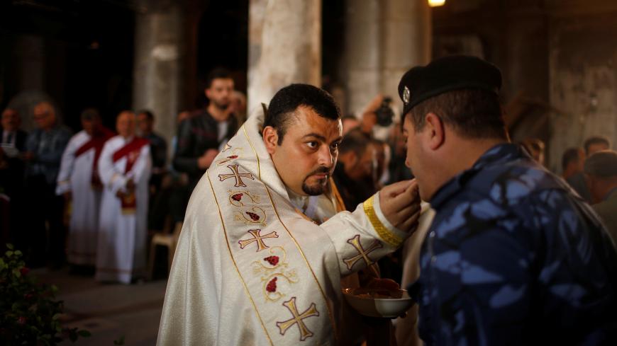 Iraqis attend the first Palm Sunday procession in the burnt out main church of the Christian city of Qaraqosh since Iraqi forces retook it from Islamic States militants, Iraq April 9, 2017. REUTERS/Suhaib Salem - RC1D40BC7F70