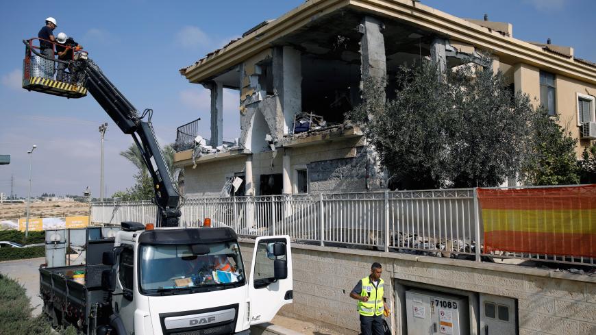 Israeli sappers stand on a crane as they work on a house that the Israeli military said was hit by a rocket fired from the Gaza Strip, in Beersheba, southern Israel October 17, 2018. REUTERS/Amir Cohen - RC165705AE00