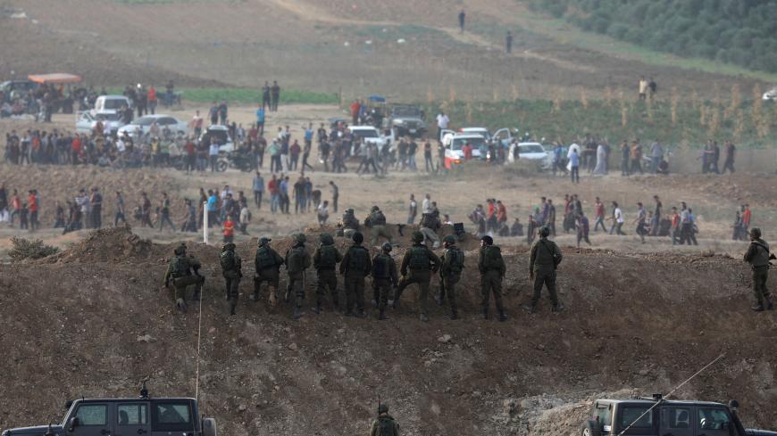 Israeli soldiers are seen next to the border fence on the Israeli side of the Israel-Gaza border as Palestinians protest on the Gaza side of the border, Israel October 19, 2018  REUTERS/Amir Cohen - RC16D6B86910