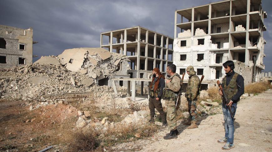 Syrian rebel-fighters from the National Liberation Front (NLF) inspect the rubble of a building destroyed by a reported air strike from the day before in the rebel-held al-Rashidin district of western Aleppo's countryside near Idlib province, on November 26, 2018. - Air strikes hit the edges of Syria's last major rebel stronghold west of Aleppo on November 25, the Britain-based Syrian Observatory for Human Rights monitor said a day after an alleged toxic attack on the regime-held city. The SOHR said regime
