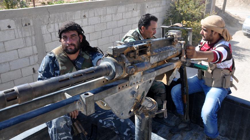 Syrian soldiers and pro-regime militiamen man a heavy machine-gun mounted on the back of a pickup truck as they ride in the recently retaken desert town of Al-Qaryatain on October 26, 2017.
The Syrian Observatory for Human Rights, a Britain-based monitor, reported on October 23, 2017 that Islamic State (IS) group militants massacred more than 100 people in the desert town of Al-Qaryatain during the month before they lost it to regime forces.
Before the civil war broke out in 2011, al-Qaryatain was a symbol